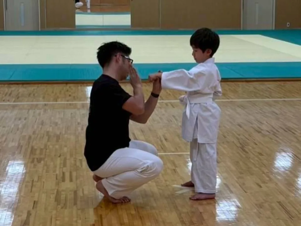 支部長が幼い道場生に正拳の構えを教えているところ