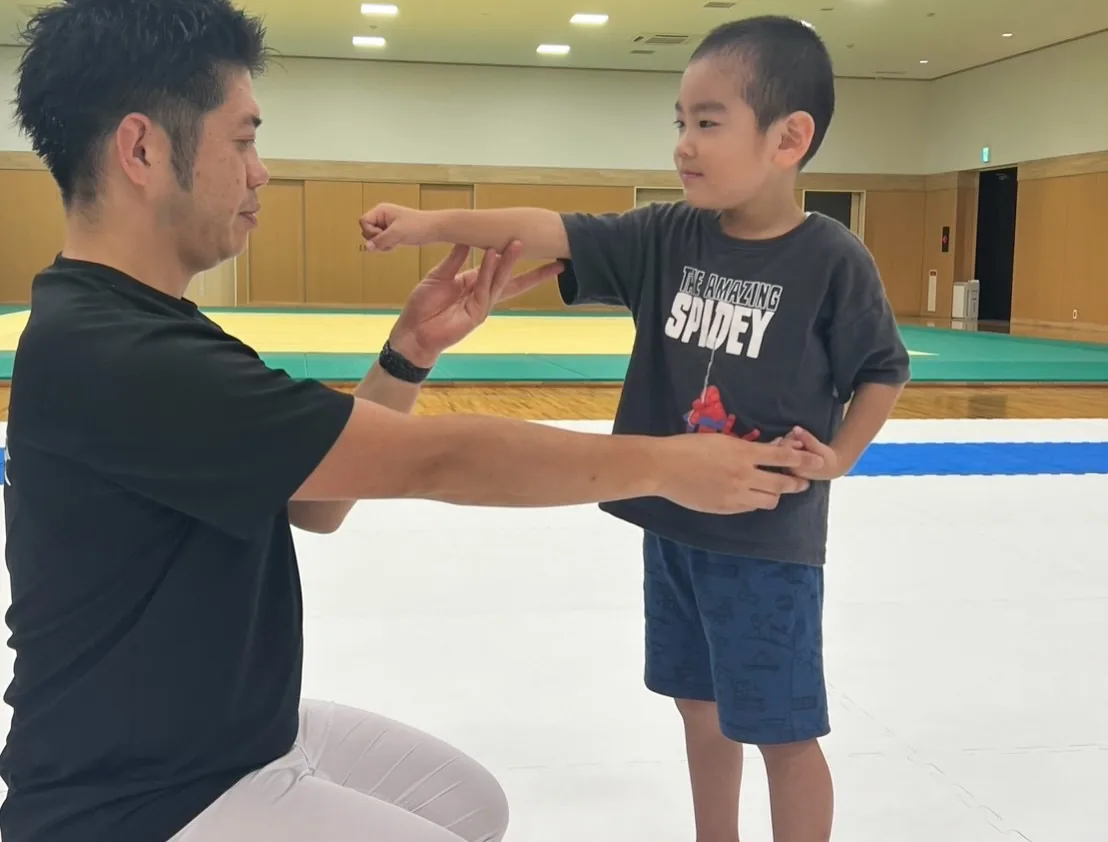 支部長が体験に来た子どもに突きの形を教えているところ